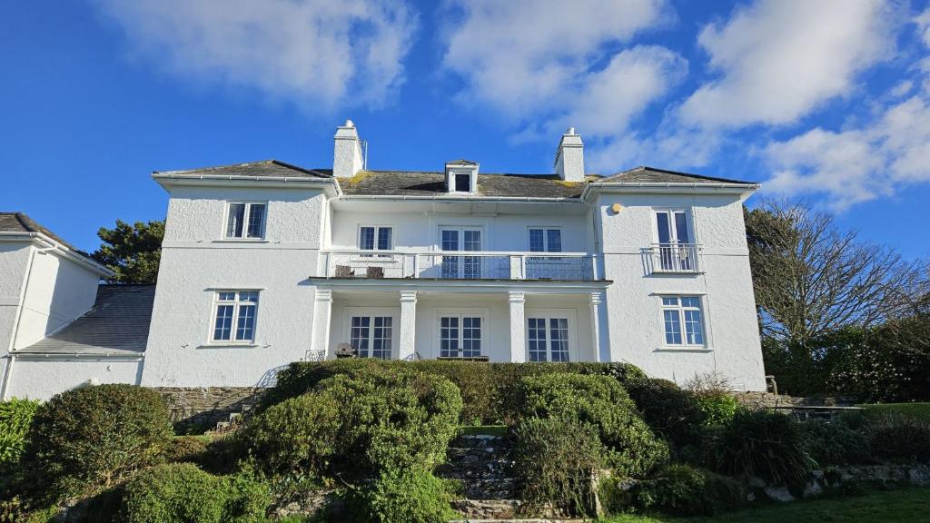 a large white house with a balcony on it at The White House in Saint Mawes