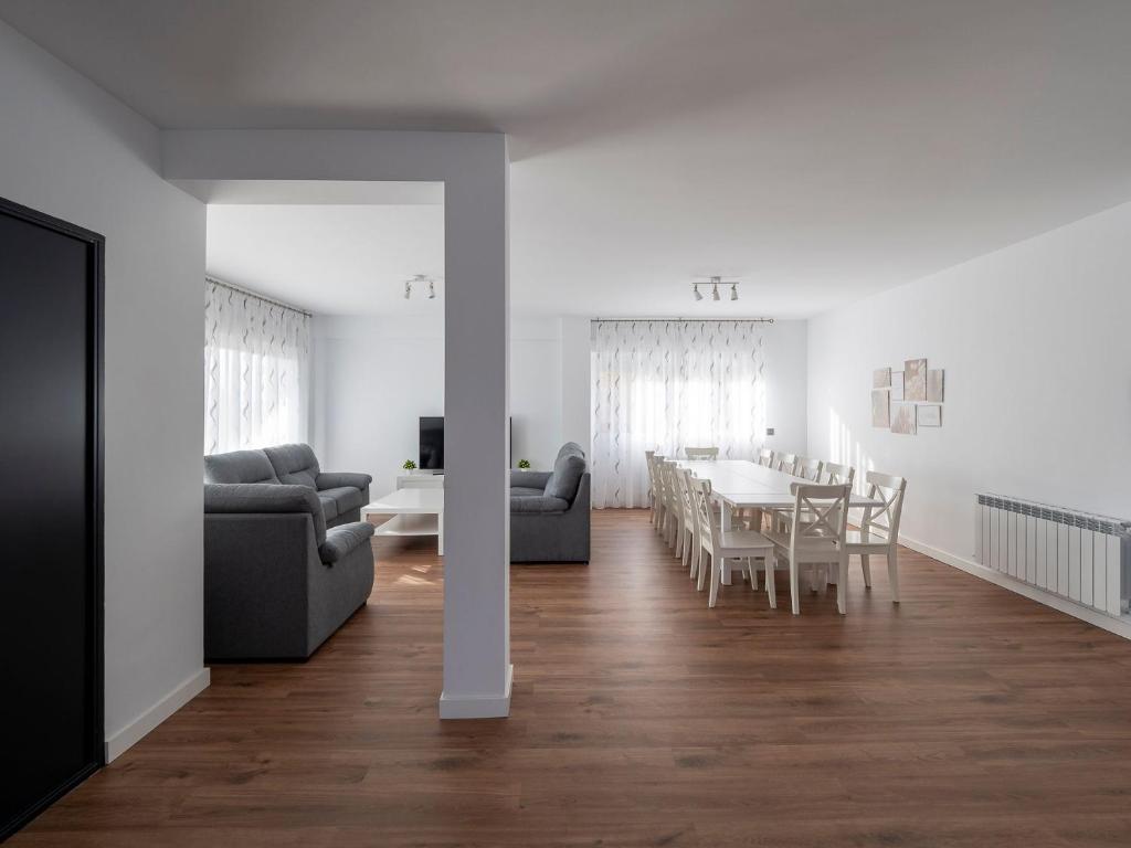 a white living room with a table and chairs at La Atalaya in Las Navas del Marqués