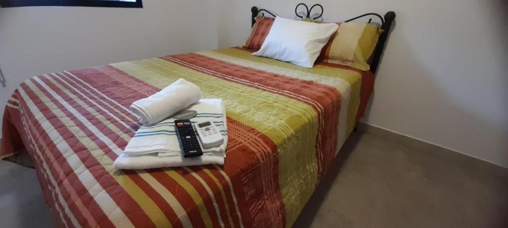 1 dormitorio con 1 cama con mando a distancia en Hermosa Suit en la Playa, en Data de Villamil
