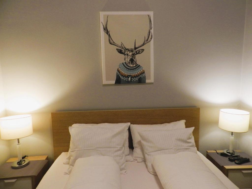 Dormitorio con cama con cabeza de ciervo en la pared en Apartament Donnka, en Cracovia