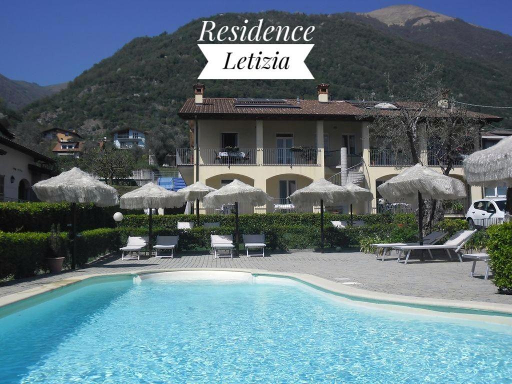 a hotel with a swimming pool in front of a building at Residence Letizia in Ossuccio