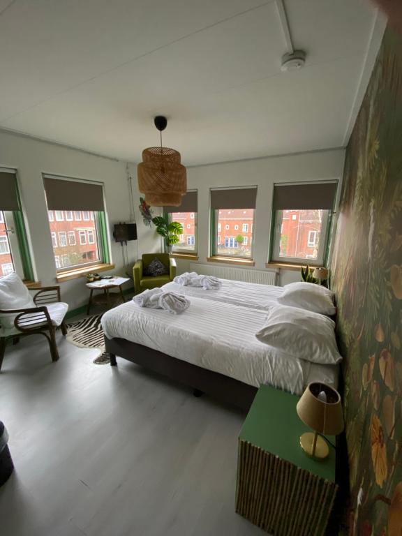 a bedroom with a large bed and some windows at Stee in Stad in Groningen