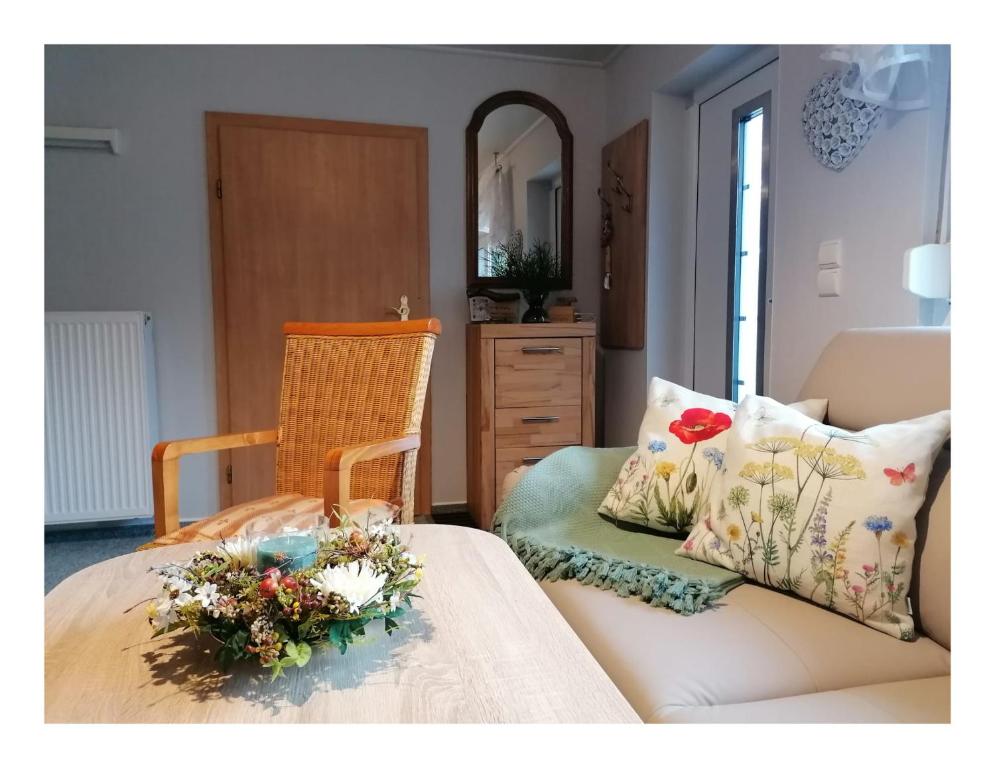 ein Schlafzimmer mit einem Sofa und einem Stuhl mit Blumen darauf in der Unterkunft Ferienhaus Fuxbau in Wohlau