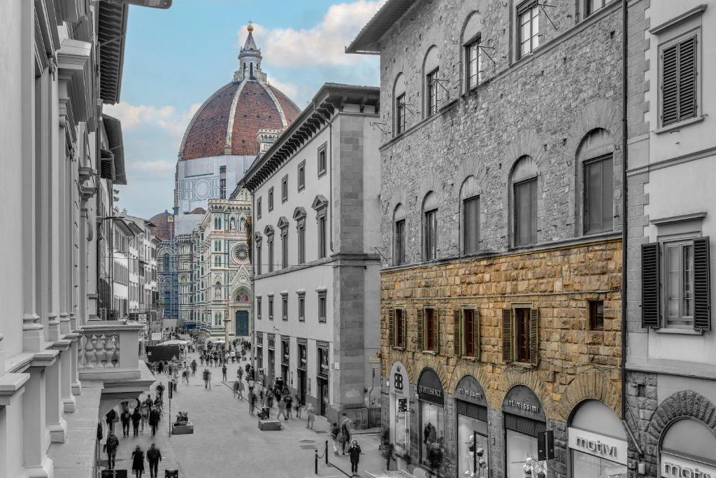 a group of people walking down a street between buildings at B&B Dell'Olio in Florence