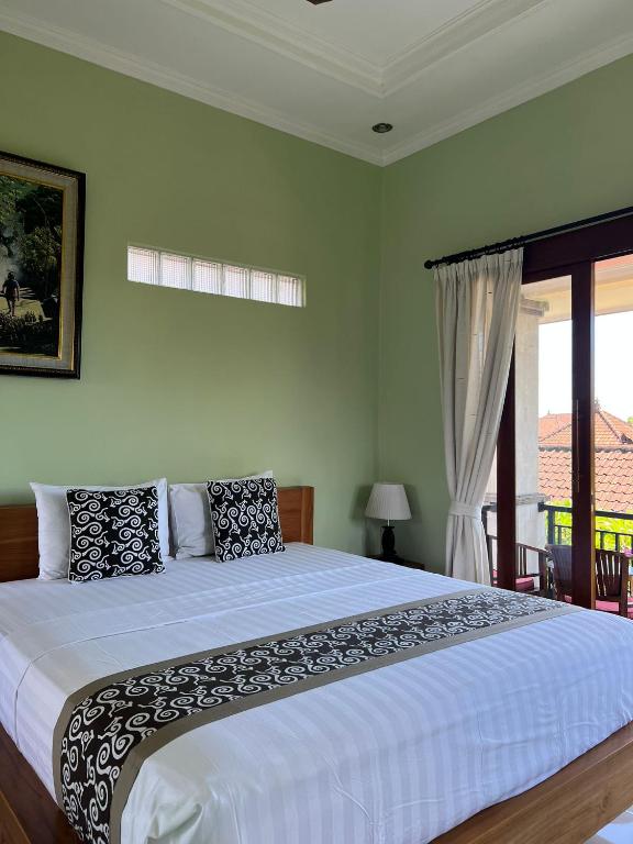 a bedroom with a large bed and a window at Sudiana House in Ubud