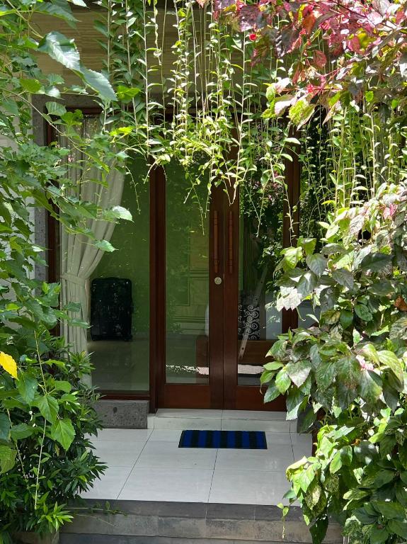 a front door of a house with plants at Sudiana House in Ubud