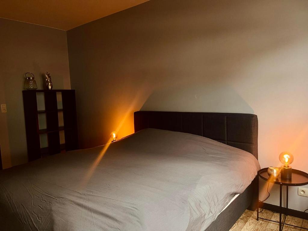 sypialnia z łóżkiem z oświetleniem na ścianie w obiekcie Le Quatre F w La-Roche-en-Ardenne