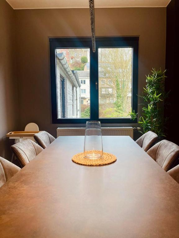a glass vase sitting on a table in front of a window at Le Quatre F in La-Roche-en-Ardenne