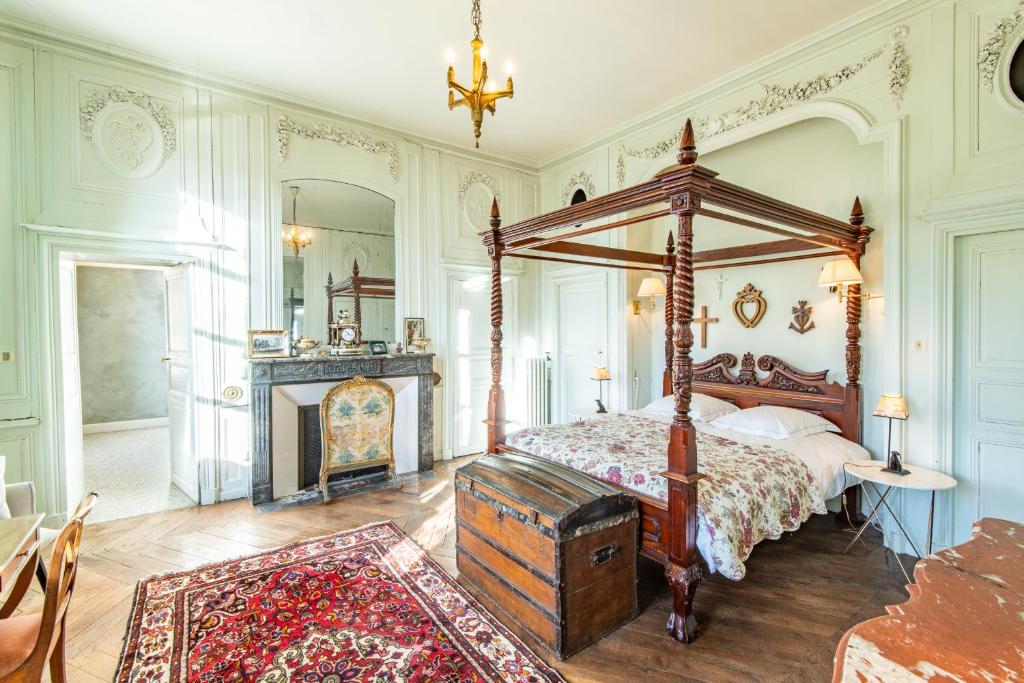 sypialnia z łóżkiem z baldachimem i kominkiem w obiekcie Les Louteaux - Splendide Château du XVIII -Piscine- Parc de Lamas w mieście Chézy