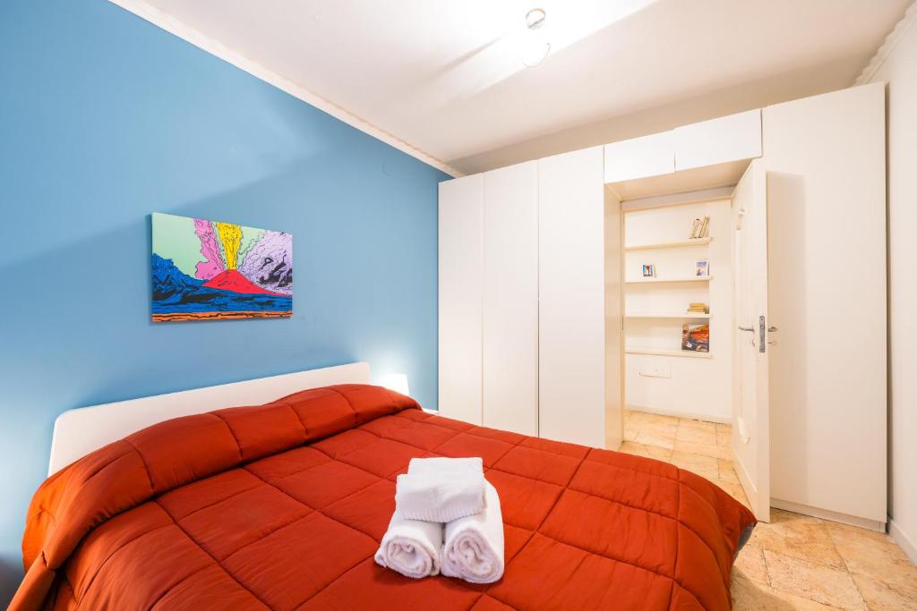 um quarto com uma cama vermelha com duas toalhas em Amedeo Comfort Apartment at Chiaia by Napoliapartments em Nápoles