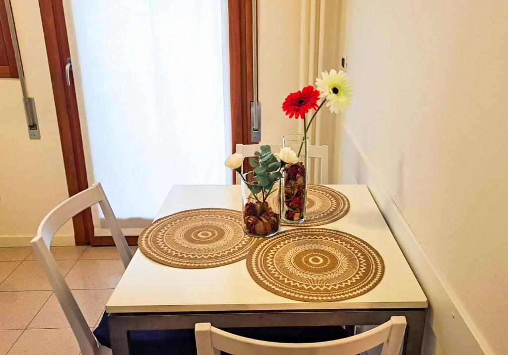 a table with a vase of flowers on it at Sweet HOME GEMMA in Mestre