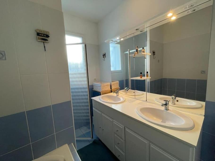 a bathroom with two sinks and a large mirror at Maison de vacances : Bord de mer in Saint-Pierre-dʼOléron