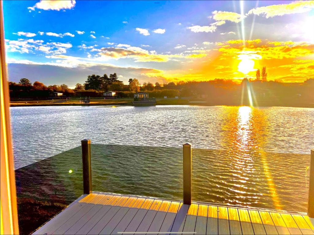 a view of a lake with the sun setting at Brackenborough Lakes Resort in Louth