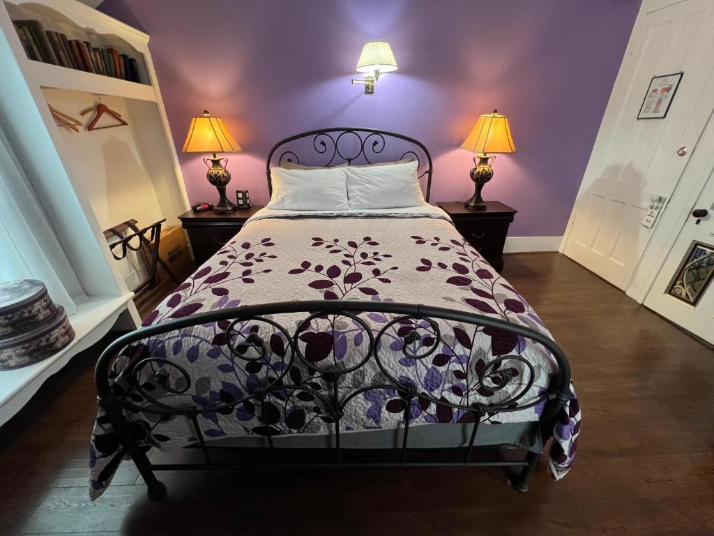 Un dormitorio con una cama negra con paredes moradas en The Gridley Inn B&B, en Waterloo