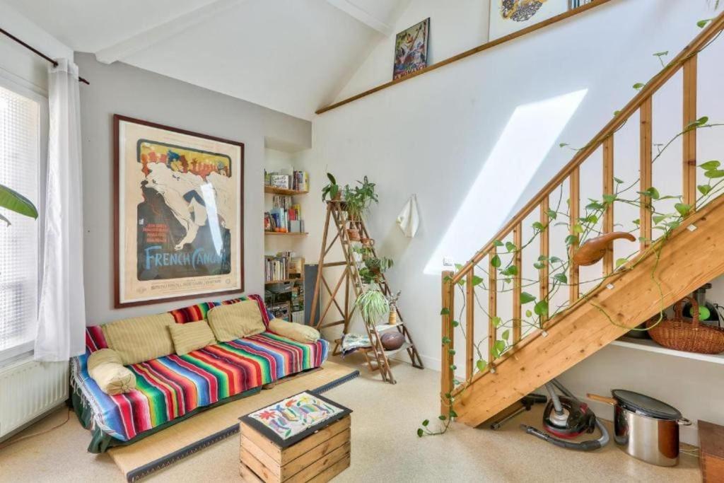 un salon avec un canapé et un escalier dans l'établissement calme et verdure à Paris, à Paris