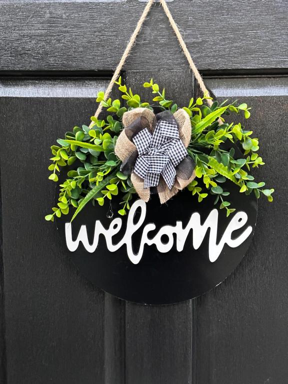 a welcome sign hanging on a wall with a plant at Vibrant comfort (Suitable for Contractors,ShortStays and LongStays) in Portsmouth