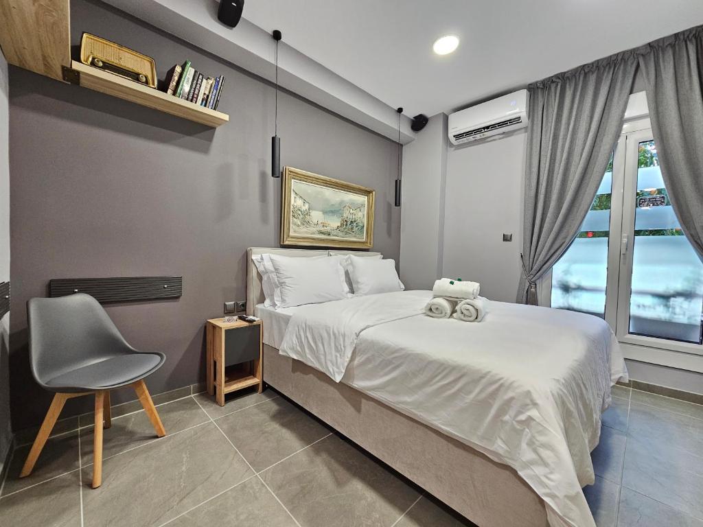 una camera con un letto e una sedia e una finestra di DIONE Luxury Business Suite in the heart of Athens ad Atene