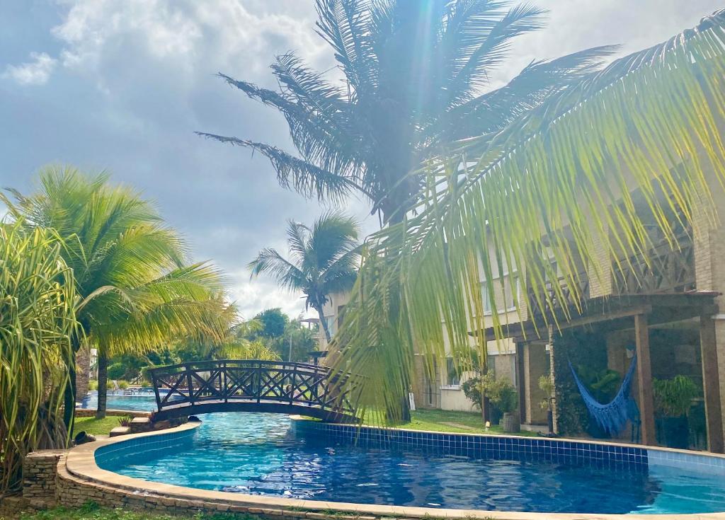 een zwembad voor een gebouw met palmbomen bij Pipa Paradise, Central, Praia do amor in Pipa