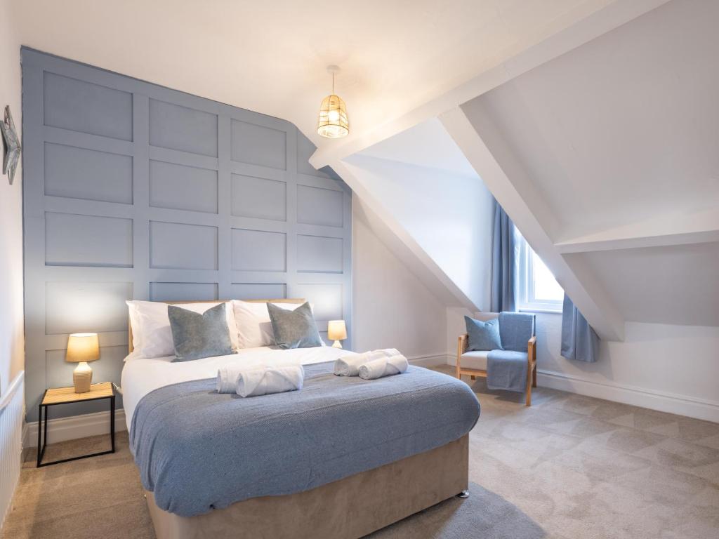 a bedroom with a king sized bed and a chair at Cosy Coastal Apartment in Whitley Bay