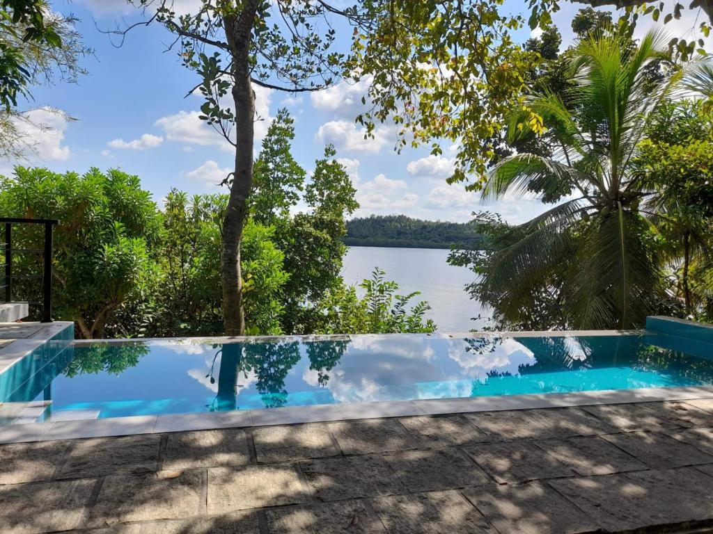 una piscina con vistas a un cuerpo de agua en Villa one en Balapitiya