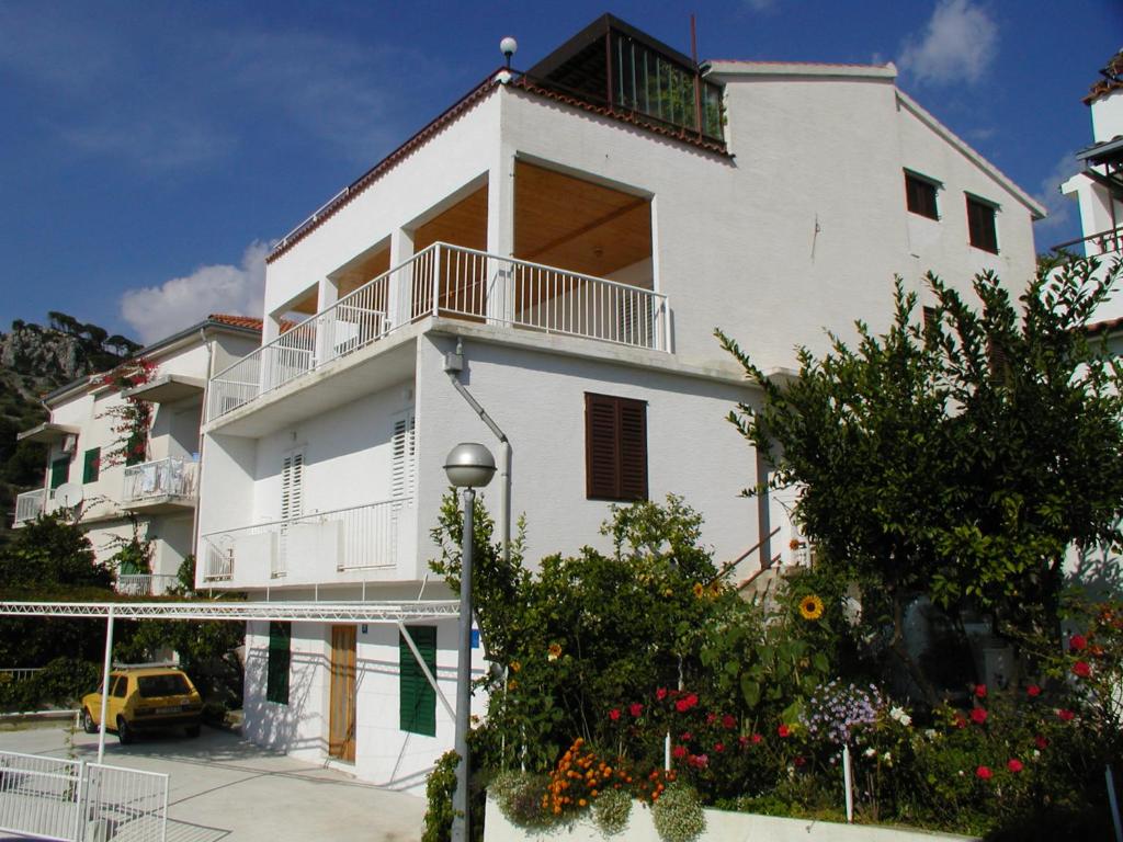 a white building with a balcony on top of it at Villa BORIĆ DARKO in Podgora