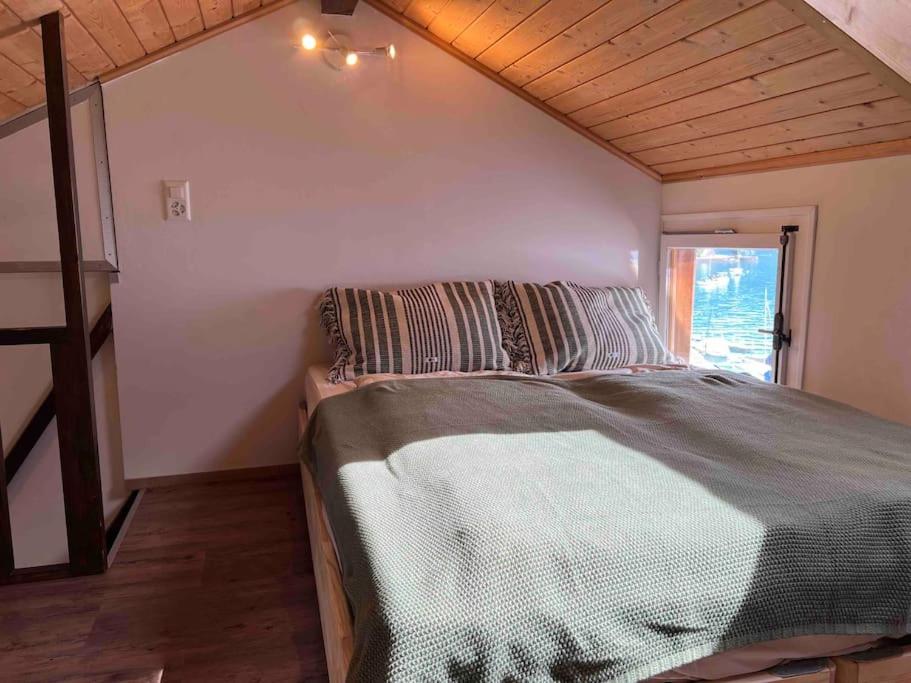 1 dormitorio con 1 cama grande en una habitación en Bijou Loft - Charming Loft on Lake Thun near Interlaken en Merligen