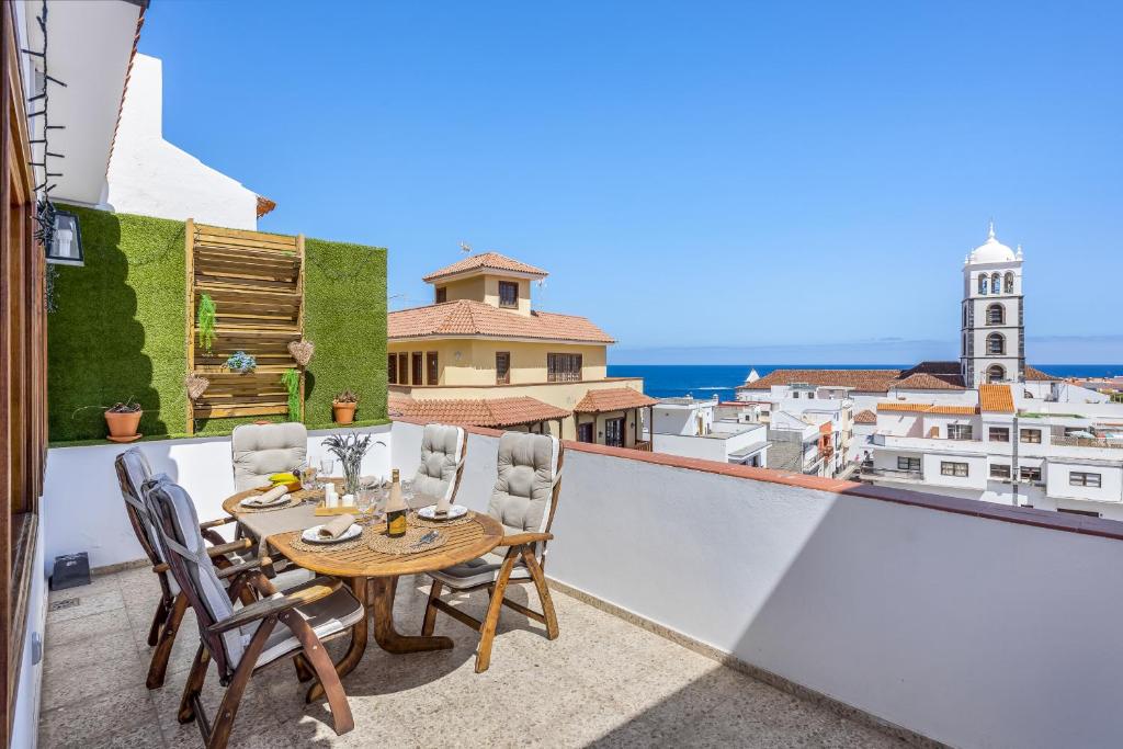 een patio met een tafel en stoelen op een balkon bij Central Penthouse, close to the Natural pools with Big terrace, ocean & city view in Garachico