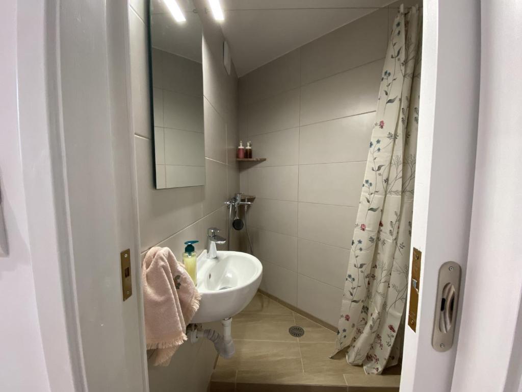ein kleines Bad mit einem Waschbecken und einem Spiegel in der Unterkunft Azure Studio in Athen
