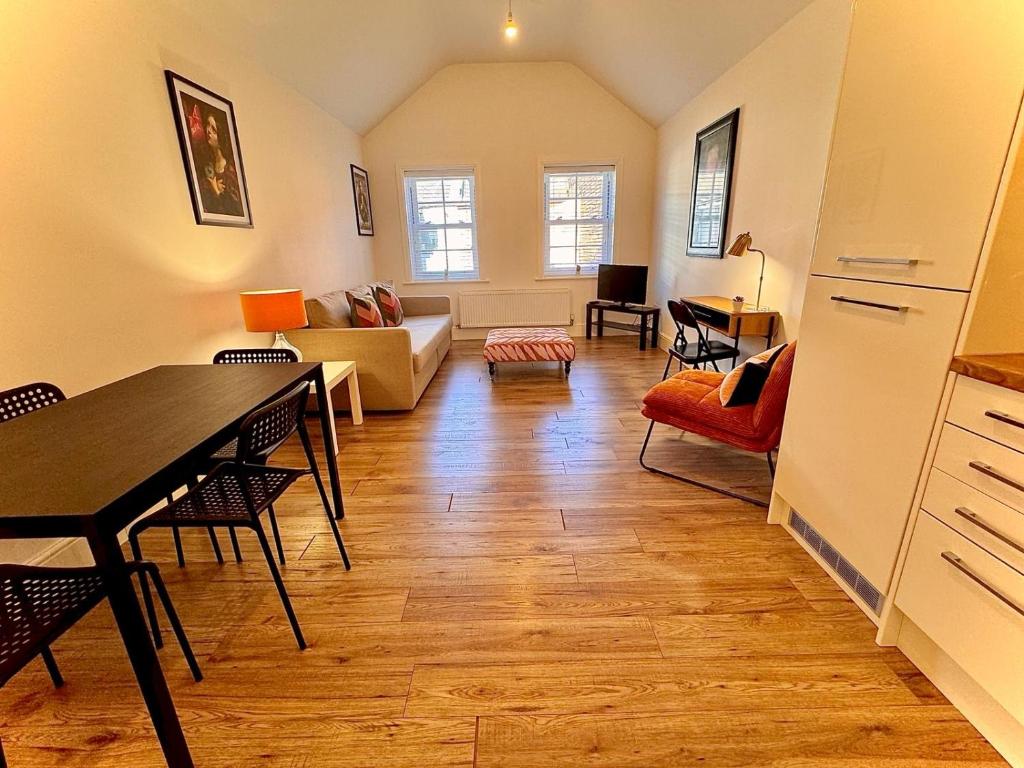 a living room with a table and a couch at Cosy town centre apartment in Bedford