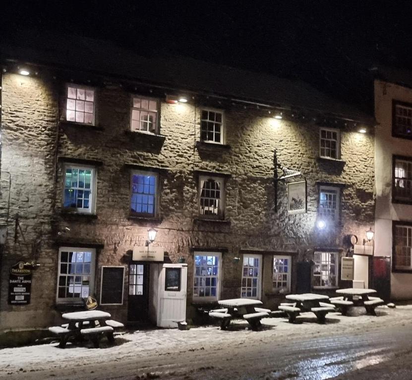 a group of picnic tables in front of a building at night at The Dante arms in Middleham