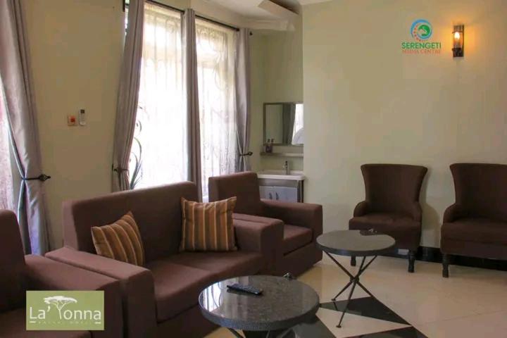 a living room with a couch and two chairs and a table at LATONA SAFARI HOTEL in Mugumu