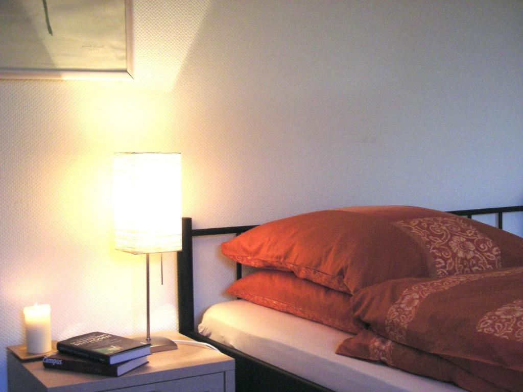 una camera da letto con un letto con una lampada e una candela di Ferienwohnung in Preußisch Oldendorf a Preußisch Oldendorf