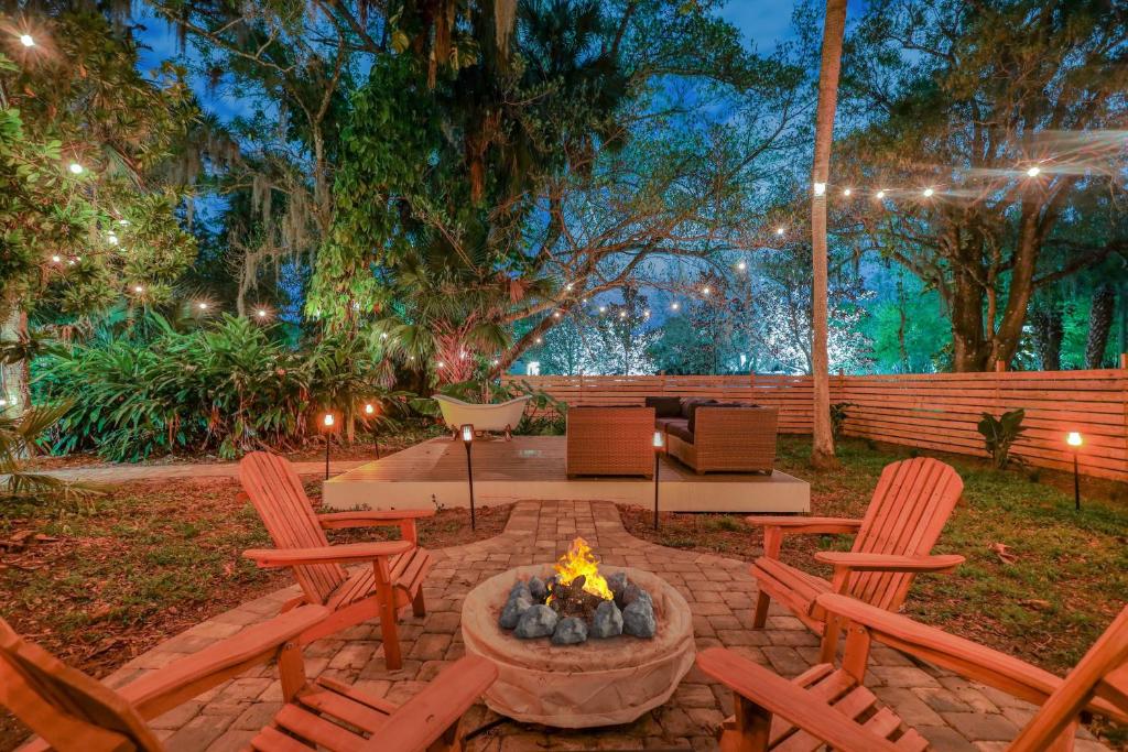 a patio with chairs and a fire pit at night at 1920s Speakeasy, Hot Tub, Horses, 5mi to beach in Vero Beach