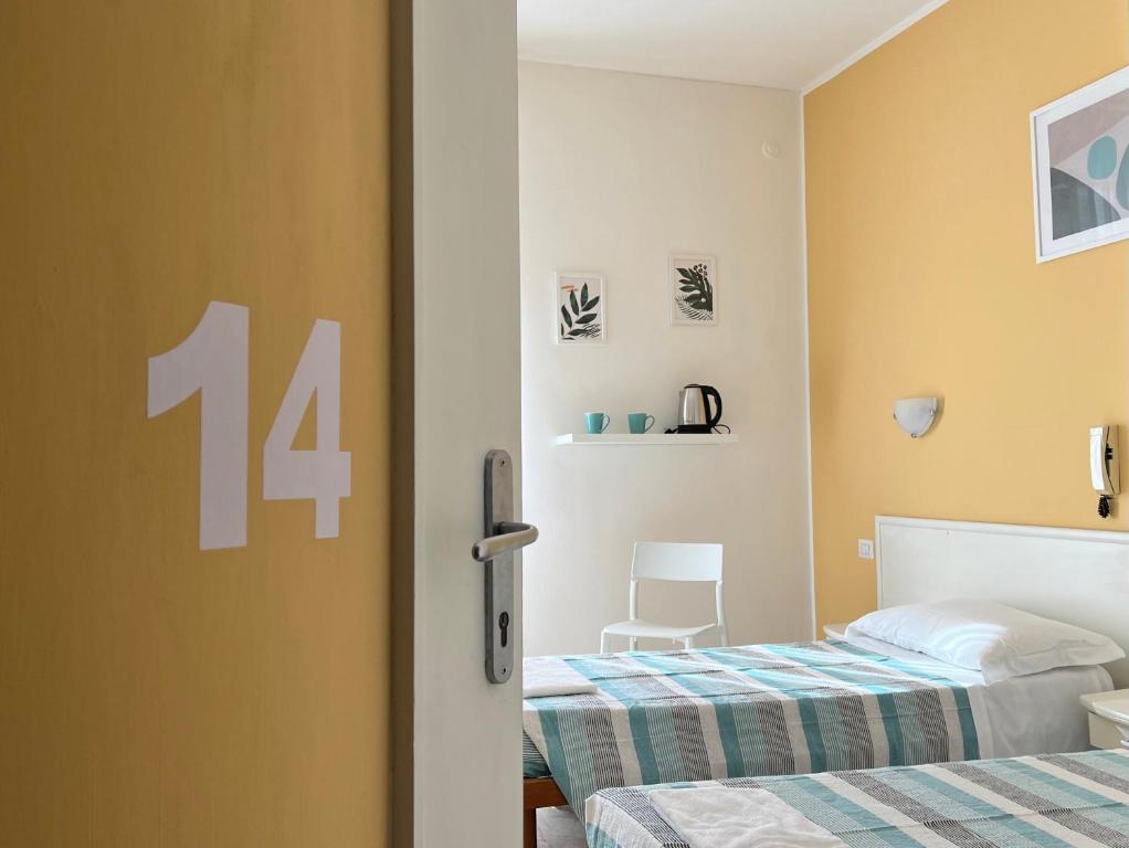 a bedroom with two beds and a door with the number at Hotel Parini in Cesano Boscone