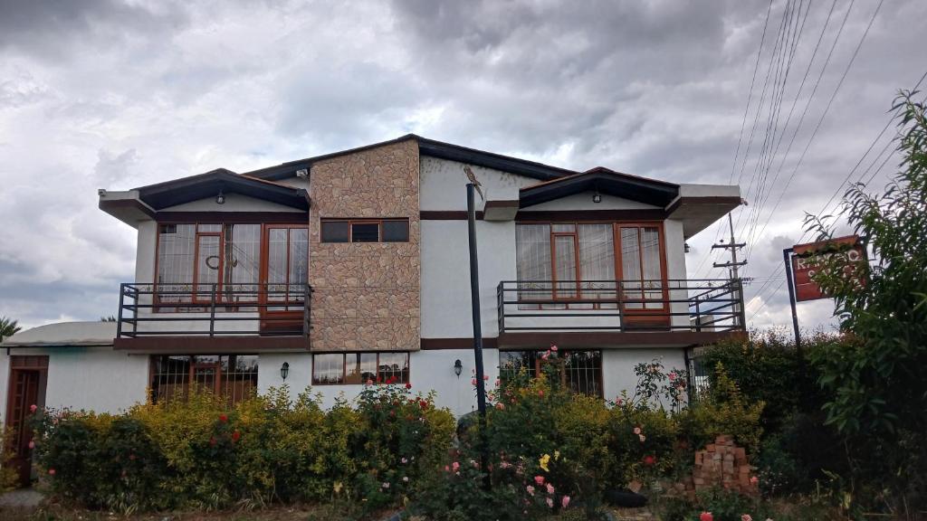 a house with balconies on the side of it at Cabaña el Rincon Del Lago in Paipa