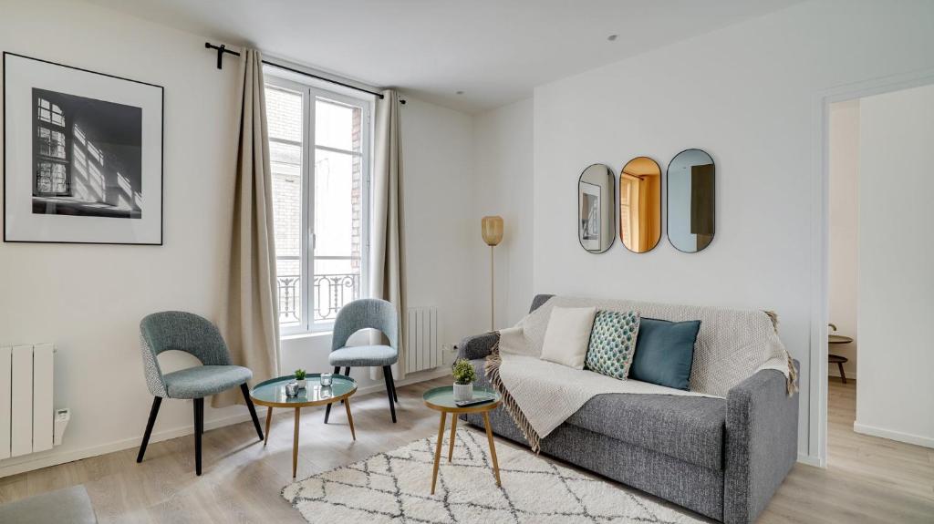 a living room with a couch and a table and chairs at 154 Suite Phil - Superb apartment in Paris in Paris
