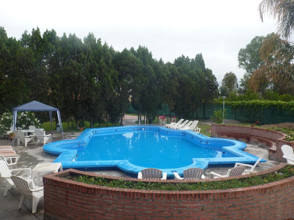 une grande piscine avec des chaises et une table dans l'établissement Hotel Aybal, à Salta