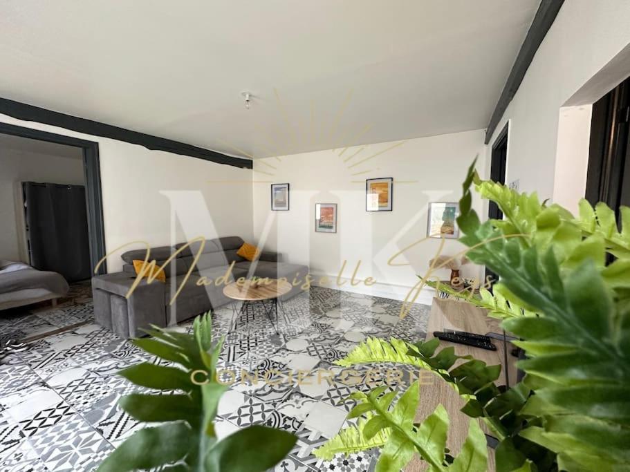 - un salon avec un canapé et des plantes dans l'établissement Le Vintage- bords de l'Yonne, à Sens