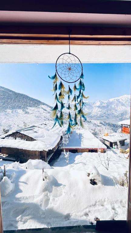 a window with a view of a snow covered mountain at Jumanji homestay in Nagar
