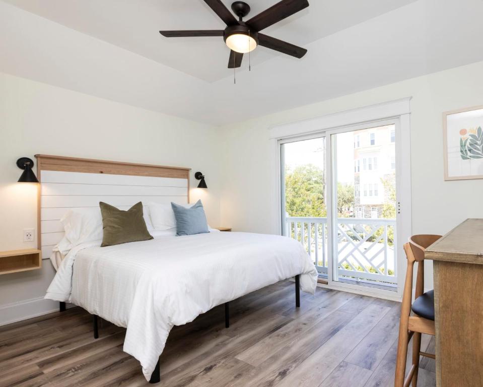 a white bedroom with a bed and a ceiling fan at The Princess Anne 200 Inn at Old Beach in Virginia Beach