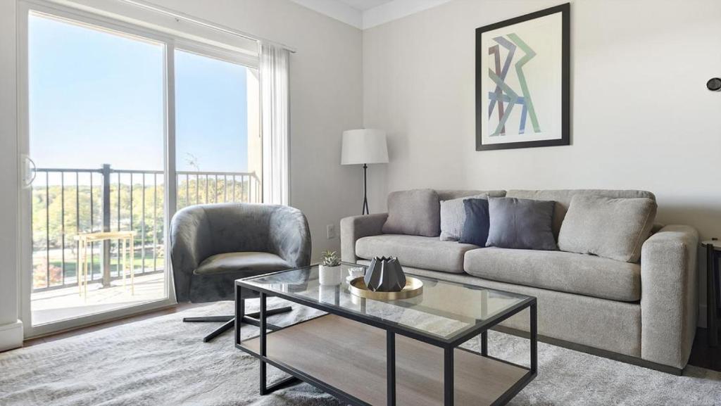 uma sala de estar com um sofá e uma mesa em Landing Modern Apartment with Amazing Amenities (ID1180X314) em Creve Coeur