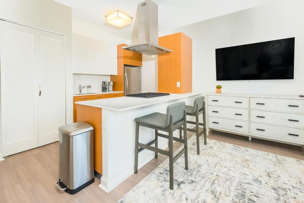 a kitchen with a counter with stools and a tv at Landing Modern Apartment with Amazing Amenities (ID634) in Chicago
