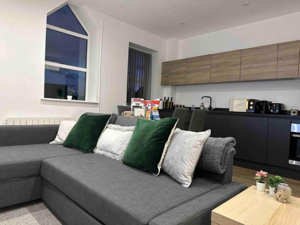 a living room with a gray couch with green pillows at New Stunning 2-Bedroom Apartment - Sleeps 4 in Bolton