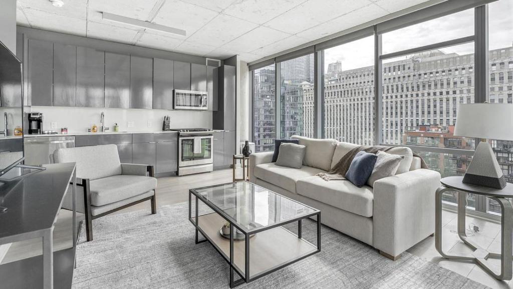 a living room with a couch and a table at Landing Modern Apartment with Amazing Amenities (ID8152X03) in Chicago