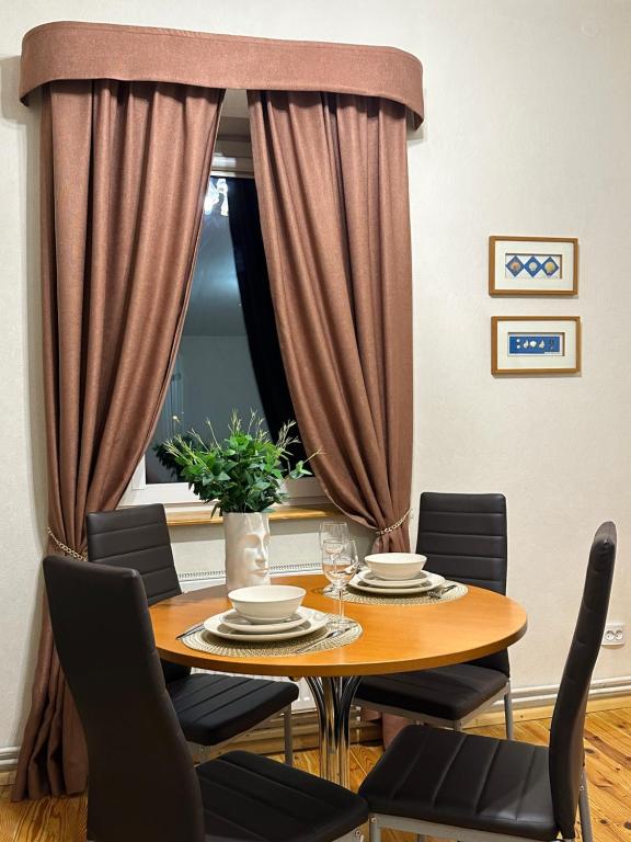 uma sala de jantar com uma mesa de madeira com cadeiras em Viesu māja V.Seiles ielā em Rezekne