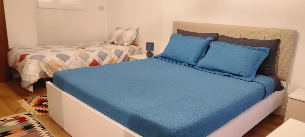 uma cama com lençóis azuis num pequeno quarto em Apartament Center Tirana em Tirana