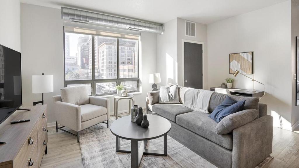 een woonkamer met een bank en een tafel bij Landing Modern Apartment with Amazing Amenities (ID1231X251) in Saint Paul