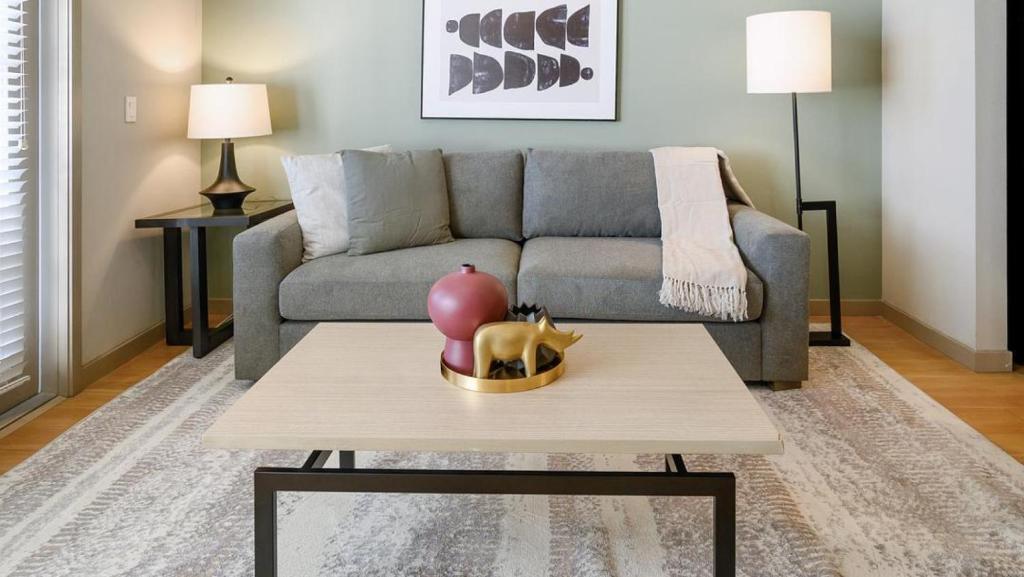 un soggiorno con divano e tavolo di Landing Modern Apartment with Amazing Amenities (ID8210X91) a Orlando