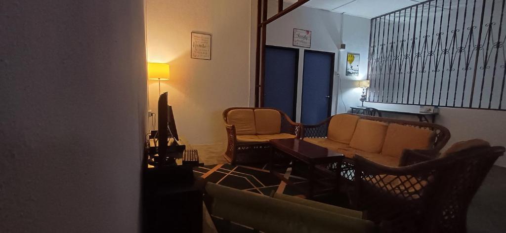 - un salon avec un canapé et des chaises dans l'établissement Cozy Nature Homestay - ADS Printing, à Nibung Tebal