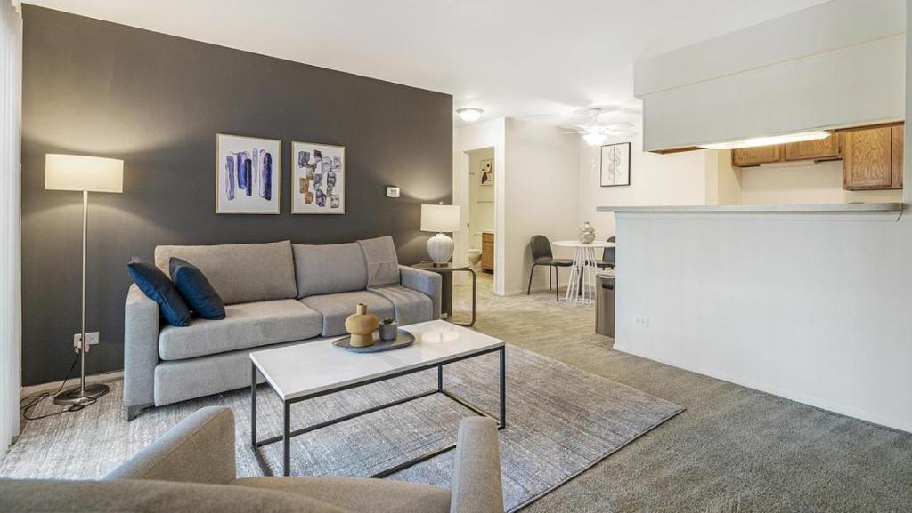 uma sala de estar com um sofá e uma mesa em Landing Modern Apartment with Amazing Amenities (ID6248X21) em Buffalo Grove